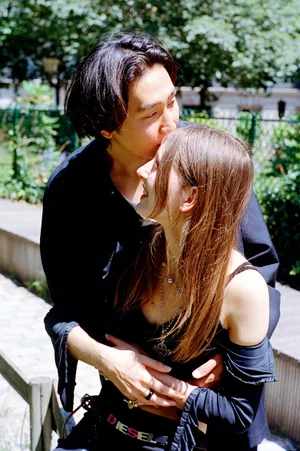 Una giovane coppia si abbraccia in un ambiente soleggiato all’aperto, con l’uomo che bacia la fronte della donna. Anna Breit / Archivi connessi