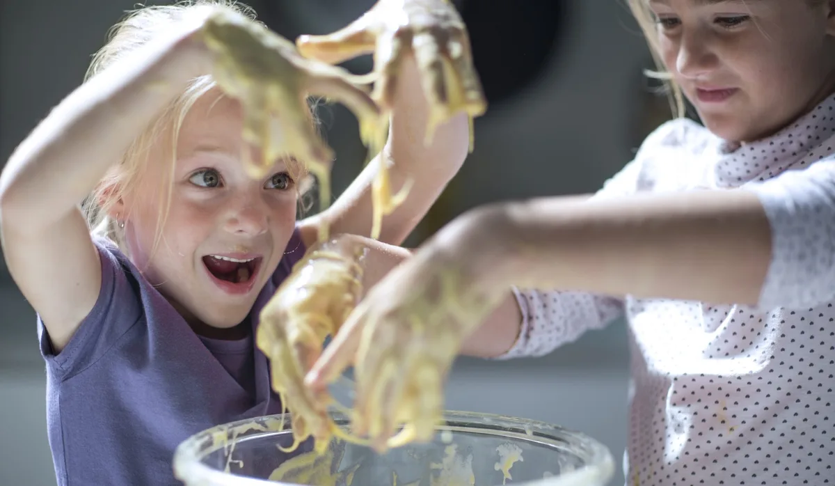 Girls baking in kitchen Ironie im Familienalltag: zwei Mädchen beim Backen