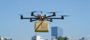 CLOSE UP: UAV drone delivery delivering big brown post package i Berufe der Zukunft: Drohnenverkehrsmanager/in