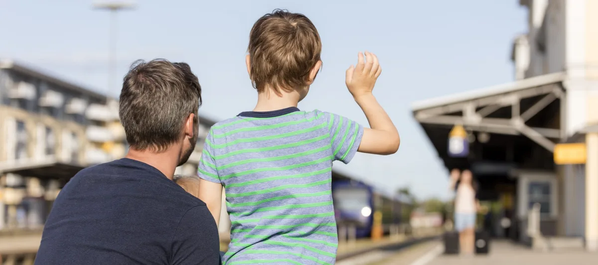 Son with father waving to mother on platform Alleinerziehende Eltern: Ein Junge ist bei seinem Vater und winkt seiner Mutter