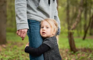 frisch-fotografie.de Una bambina si aggrappa alla gamba del padre