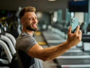 gym, sport, fitness, exercise, health, healthy, training, phone, selfie, photo, portrait, self-portrait, posing, camera, technology, smartphone, mobile, break, mobile phone, running Manosphere: Man at the gym poses for social media