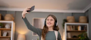 Teenage girl making video call holding smartphone Ein Mädchen fotografiert sich mit dem Handy.
