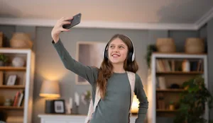Teenage girl making video call holding smartphone Ein Mädchen fotografiert sich mit dem Handy.