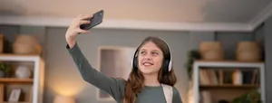 Teenage girl making video call holding smartphone Ein Mädchen fotografiert sich mit dem Handy.