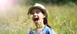 Ein Mädchen steht in einer wilden Blumenwiese im Thüringer Wald Zecken, Zeckenstich: fröhliches Mädchen in hoher Blumenwiese