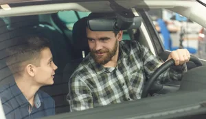 Handsome mature man and his young son buying a new automobile together Erziehung: Vater und Sohn im Auto