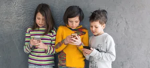 Header_Social_Media_Addiction Social media: Three small children staring at a smartphone.
