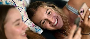 24-10-pubertaet-dossier-hauptartikel-schweizer-elternmagazin-fritz-und-fraenzi-hg Pubertät: Zwei Teenager-Mädchen liegen mit ihren Smartphones auf dem Bett