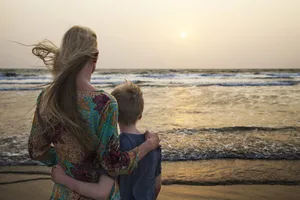 Mère et fils regardant le coucher du soleil Parent seul : une mère avec son fils