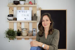 Frau-Janik-vor-der-Tafel-mit-Kochzutaten-im-Glas-scaled Mehr Theorie