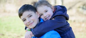 Huckepack Geschwister: ein älterer Bruder nimmt seine Schwester Huckepack