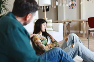 Un père discute avec sa fille de certains problèmes Un père discute des cybercriminels avec sa fille adolescente dans le salon
