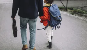 Low section of father and son holding hands and walking on footpath Trennung: Vater und Sohn spazieren Hand in Hand