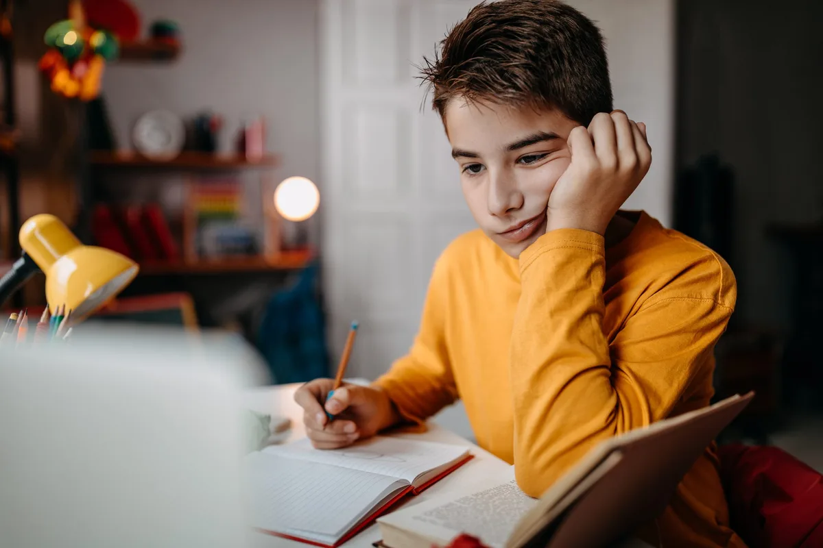 Un adolescent faisant ses devoirs à la maison Un garçon en train d'étudier