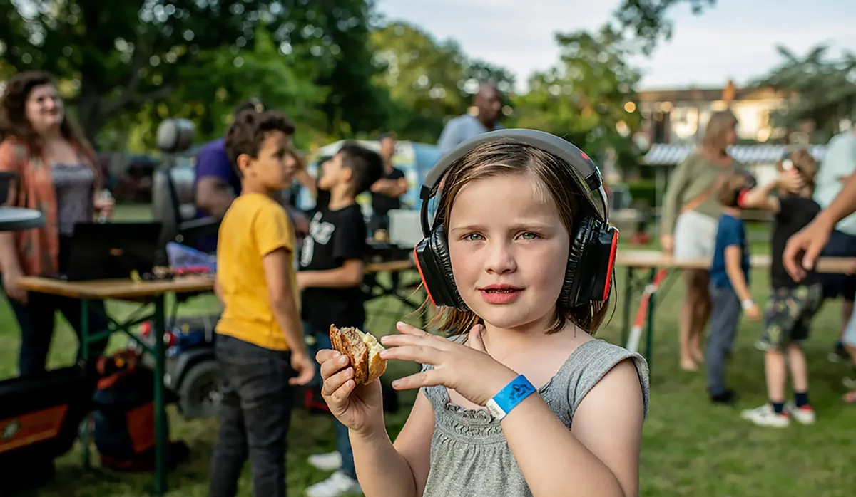Molly wearing headphones at the silent disco at Majella Parc Mädchen mit Kopfhörern hält in der Hand ein Sandwich