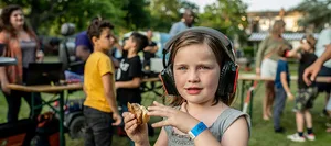 Molly wearing headphones at the silent disco at Majella Parc Mädchen mit Kopfhörern hält in der Hand ein Sandwich