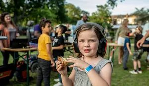 Molly wearing headphones at the silent disco at Majella Parc Mädchen mit Kopfhörern hält in der Hand ein Sandwich