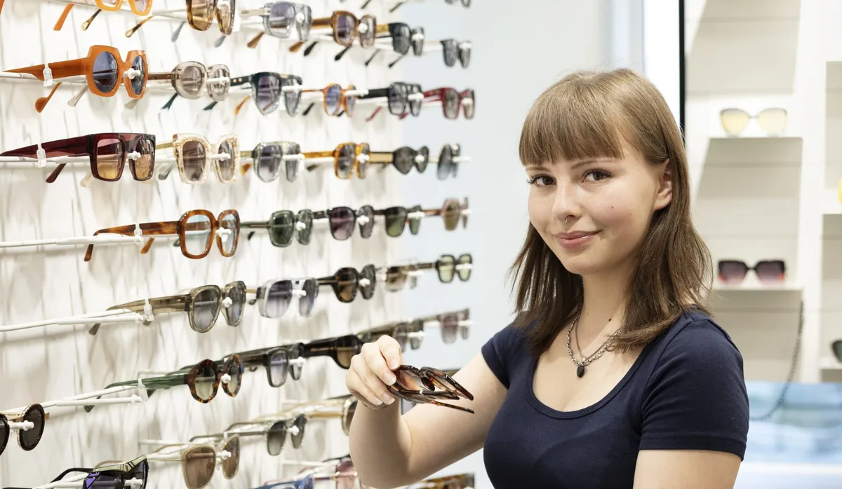 26-09-choix-de-carrière-2026-Louisa-Freitag-opticienne Opticienne : une jeune femme présente une paire de lunettes dans le magasin