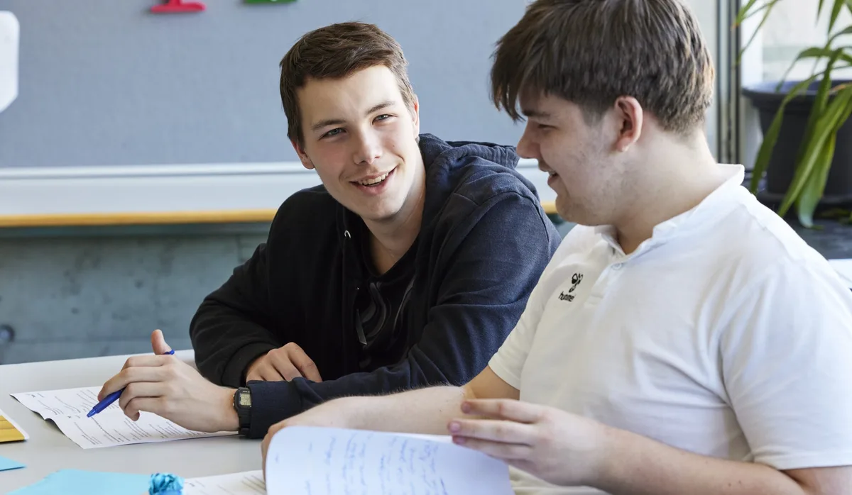 26-07-glueck-als-schulfach-schweizer-elternmagazin-hg Glück als Schulfach: Zwei Schüler reden im Schulzimmer miteinander