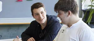 26-07-glueck-als-schulfach-schweizer-elternmagazin-hg Glück als Schulfach: Zwei Schüler reden im Schulzimmer miteinander