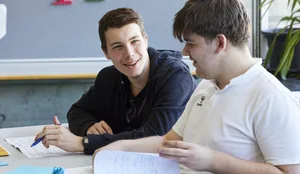 26-07-glueck-als-schulfach-schweizer-elternmagazin-hg Glück als Schulfach: Zwei Schüler reden im Schulzimmer miteinander