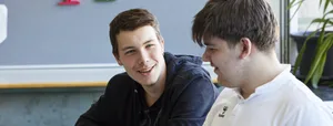 26-07-glueck-als-schulfach-schweizer-elternmagazin-hg Glück als Schulfach: Zwei Schüler reden im Schulzimmer miteinander