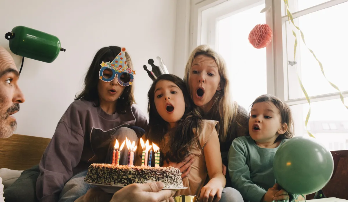 Anniversaire d'enfant : la famille souffle les bougies du gâteau. Anniversaire d'enfant : la famille souffle les bougies du gâteau.