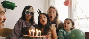 Kindergeburtstag: Familie bläst Kerzen auf der Torte aus. Kindergeburtstag: Familie bläst Kerzen auf der Torte aus.