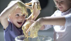 Ragazze che preparano dolci in cucina L’ironia nella vita quotidiana della famiglia: due ragazze intente a preparare dolci
