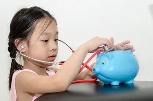 Ma_dchen-untersucht-ihr-Sparschwein-Wie-Kinder-sparen-lernen What do children need to know about money?