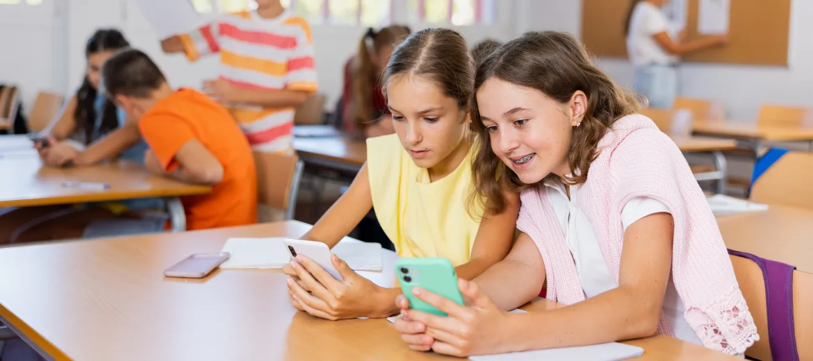 24-10-smartphones-schule-lch-beat-schwendimann-schweizer-elternmagazin-fritz-und-fraenzi-hg Zwei Mädchen mit ihren Smartphones in der Schule.