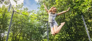 16-8-trampolin-verletzungen-schweizer-elternmagazin-hg Trampolin springen bei Kindern: Ein Mädchen springt gerade auf dem Trampolin ganz hoch.