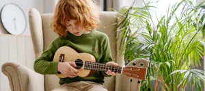 21_KIGA_3_Instrument_HL Esercitarsi con uno strumento: Un bambino suona l'armonica con gli spartiti