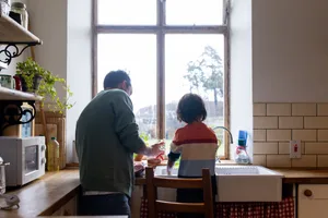 Lavorare in squadra in cucina Separazione: un padre con suo figlio mentre lavano i piatti