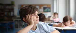 A child daydreaming, looking out the window into a classroom Schutz vor Hitze: Primarschüler im Klassenzimmer