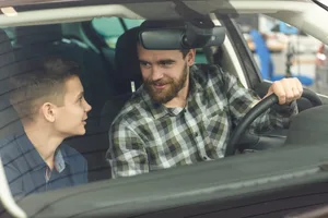 Un uomo maturo e affascinante e suo figlio piccolo che acquistano insieme una nuova automobile Educazione: padre e figlio in macchina