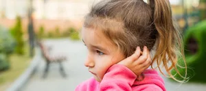 24-10-mittelohrenentzuendung-schweizer-elternmagazin-hg Ein Mädchen mit Mittelohrenentzündung hält seine Hand ans schmerzende Ohr