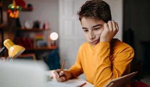 Teenage boy doing homework at home Ein Junge am lernen