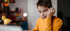 Teenage boy doing homework at home Ein Junge am lernen