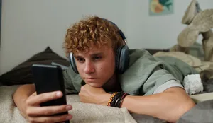 Hatespeech: Jugendlicher im Bett am Handy Hatespeech: Jugendlicher im Bett am Handy
