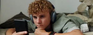 Hatespeech: Jugendlicher im Bett am Handy Hatespeech: Jugendlicher im Bett am Handy