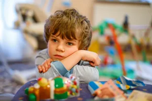 Portrait of a sad little boy on his birthday. Child with lots of toys Argument with sister: eight-year-old boy is frustrated