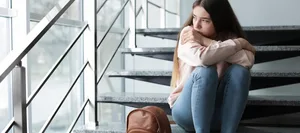 depressionen-bei-jugendlichen-teenagern-psychische-erkrankung-fritz-und-fraenzi-neue-ansaetze-bold-hg Eine sehr junge Frau scheint depressiv und traurig zu sein. Sie sitzt auf einer Treppe.