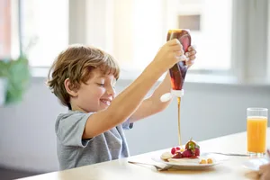 Zucker_Betty_Bossi_Fritzundfraenzi in scala Alternativa allo zucchero: un ragazzo versa uno sciroppo sul suo dessert.