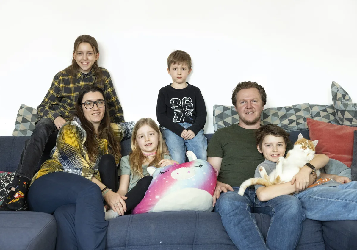 Une famille avec quatre enfants et un chat sur le canapé Une famille avec quatre enfants et un chat sur le canapé