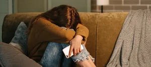 24-10-sextortion-cybermobbing-entdecken-3-fragen-an-regula-bernhard-hug-schweizer-elternmagazin-fritz-und-fraenzi-hg Sextortion: Ein Mädchen sitzt traurig auf dem Sofa