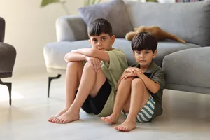 Il ragazzino birichino Litigio: due fratelli sono seduti per terra