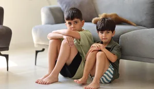 Naughty and little boy Streit: Zwei Brüder sitzen auf dem Boden