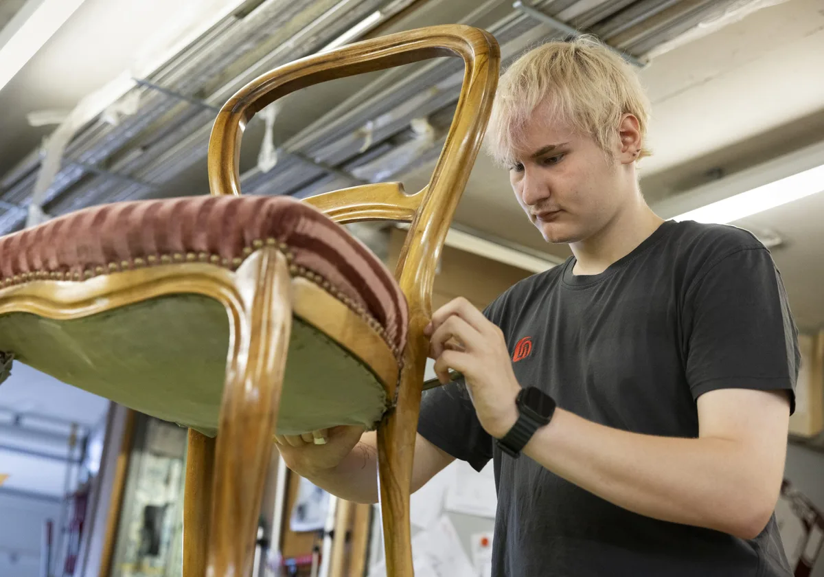 Un apprenti en situation de handicap restaure une chaise Un apprenti en situation de handicap restaure une chaise